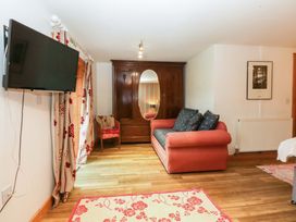 A living room with a sofa and television at Beudy Mawr in Y Felinheli