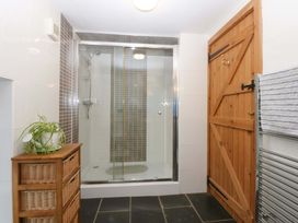 A bathroom with a shower and storage unit at Beudy Mawr Y Felinheli