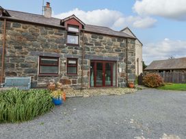 An outdoor view of a stone building with a bench at Hafod in Y Felinheli