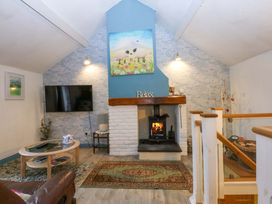 A living room with a fireplace and television at Hafod in Y Felinheli
