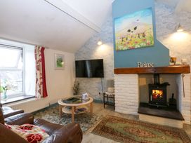 A living room with a sofa, fireplace, and television at Hafod in Y Felinheli