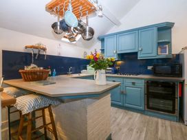 A kitchen with blue cabinets and an island at Hafod Y Felinheli