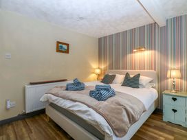 A bedroom with a bed and nightstand at Hafod Y Felinheli