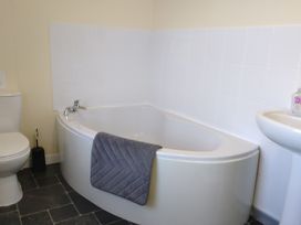 A bathroom with a bathtub, toilet, and sink at The Farmhouse in Brynsiencyn near Newborough