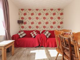 A living room with a sofa and dining table at The Farmhouse in Brynsiencyn near Newborough