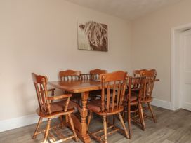 A dining room with a wooden table and chairs at The Farmhouse in Brynsiencyn near Newborough
