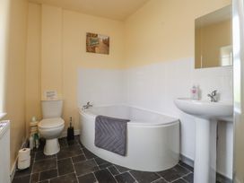 A bathroom with a bathtub, toilet, and sink at The Farmhouse in Brynsiencyn near Newborough