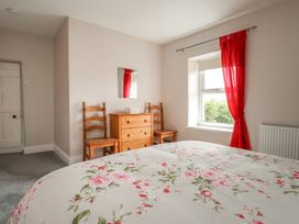 A bedroom with a bed and dresser at The Farmhouse in Brynsiencyn near Newborough