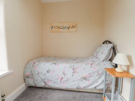 A bedroom with a single bed and bedside table at The Farmhouse in Brynsiencyn near Newborough