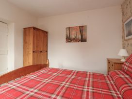 A bedroom with a bed and furniture at The Farmhouse in Brynsiencyn near Newborough