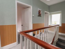 A hallway with a staircase and doors at The Farmhouse in Brynsiencyn near Newborough