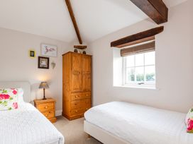 A bedroom with two beds and furniture at Carleton Mill Cottage Carlisle