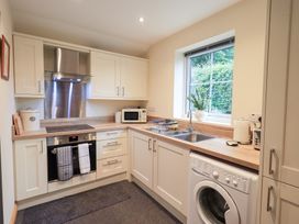 A kitchen with a stove, sink, and washing machine at Rose Cottage, Crosby on Eden near Carlisle