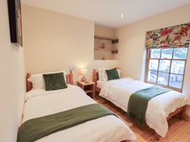 A bedroom with two beds and a lamp at Rose Cottage in Crosby on Eden near Carlisle