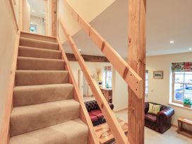 A staircase with wooden railing and sofa visible at Rose Cottage in Crosby on Eden near Carlisle