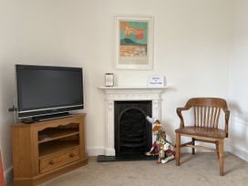 A living room with a television, chair, and fireplace at Prospect Lodge in Portinscale