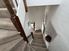 A staircase with a handrail and chandelier at Prospect Lodge in Portinscale