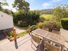 An outdoor area with a wooden table and chairs at Mell View Cottage Ullswater