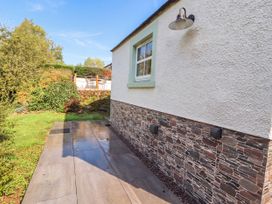 An outdoor area with a stone wall and paved path at Mell View Cottage in Ullswater