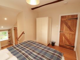 A bedroom with a bed and wardrobe at Mell View Cottage in Ullswater