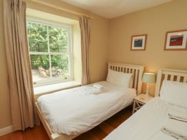 A bedroom with two beds and a window at Mell View Cottage, Ullswater