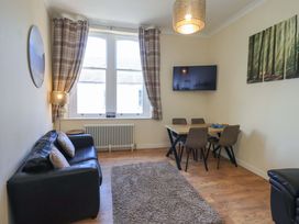 A living room with a sofa and dining area at St Johns View in Keswick