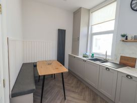 A kitchen with a table and bench at St Johns View in Keswick