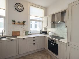 A kitchen with a clock and countertop appliances at St Johns View in Keswick