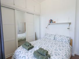 A bedroom with a bed, towels, shelf, and wardrobe at St Johns View in Keswick