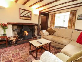 A living room with a sofa and fireplace at Mill Cottage in Garnett Bridge