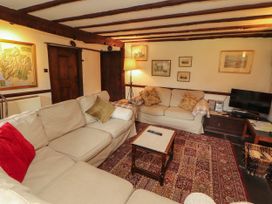 A living room with a sofa, coffee table, and television at Mill Cottage in Garnett Bridge