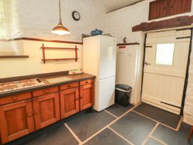 A kitchen with a fridge, oven and countertop at Mill Cottage in Garnett Bridge