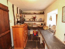 A kitchen with a dresser and shelves at Mill Cottage in Garnett Bridge