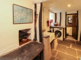 A laundry room with a sink and washing machine at Mill Cottage Garnett Bridge