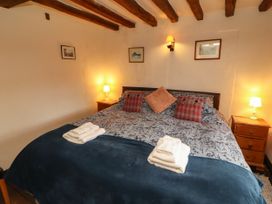 A bedroom with a bed and bedside tables at Mill Cottage Garnett Bridge