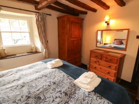 A bedroom with a bed and furniture at Mill Cottage Garnett Bridge