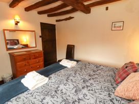 A bedroom with a bed, dresser, and mirror at Mill Cottage in Garnett Bridge