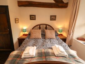 A bedroom with a bed and lamps at Mill Cottage in Garnett Bridge