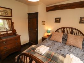 A bedroom with a bed and dresser at Mill Cottage in Garnett Bridge