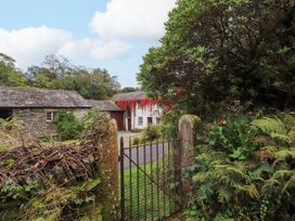 A house with a gate and foliage at Mill Cottage in Garnett Bridge