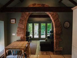 A living room with an archway leading to a patio at Carwinley Mill House Cottage Longtown