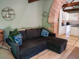 A living room with a sofa and archway at Carwinley Mill House Cottage in Longtown