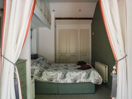 A bedroom with a bed and wardrobe at Carwinley Mill House Cottage Longtown