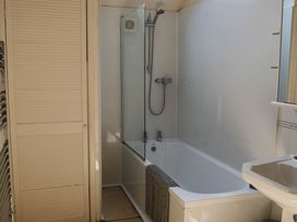 A bathroom with a bathtub and shower at Carwinley Mill House Cottage in Longtown