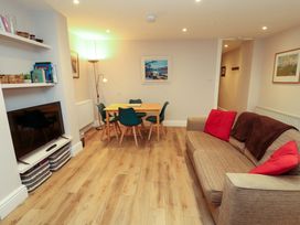 A living room with a sofa and dining area at Archers in Keswick