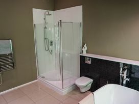 A bathroom with a shower, toilet, and bathtub at The Heronry in Longtown