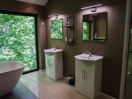 A bathroom with two washbasins and a bathtub at The Heronry in Longtown