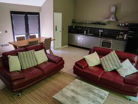 A living room with a sofa and dining table at The Heronry in Longtown
