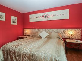 A bedroom with a bed and lamps at Stonegarth Cottage in Grasmere