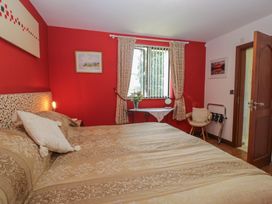 A bedroom with a bed and table at Stonegarth Cottage in Grasmere